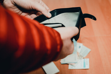 Mans hands checking wallet near desk.close up,toned.Blurred background.Soft focus.