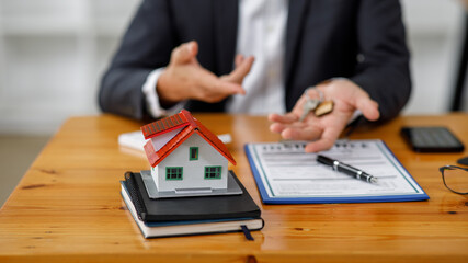 Close up house model with business man signs a purchase contract or mortgage for a home, Real estate mortgage concept.