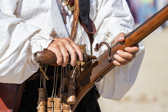 foreground hand showing the loading system of an arquebus