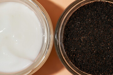 Facial scrub and cosmetological cream in open round cans
