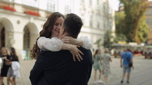 Newlyweds portrait. Lovely Caucasian bride, groom dancing on old city street. Embracing, hugging, kissing. Happy wedding couple family. Man woman in love. Bride in wedding dress. Bridegroom in jacket