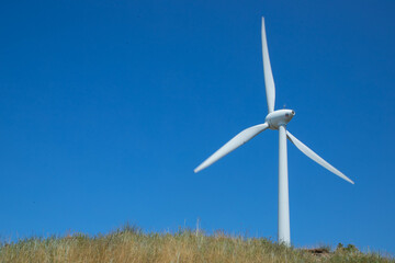 Fototapeta premium Windmill for electricity generation the background of a blue sky.