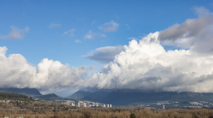 View of Cloudscape over the mountain landscape during a cloudy blue sky sunny day. Taken at Fraser Valley in Vancouver, British Columbia, Canada.