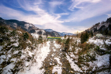 Obraz premium The train route from Chigaki Station has snow covered in winter. Toyama region railway Tateyama line, crossing the iron bridge between Senge - Moriguchi station Tateyama Japan.