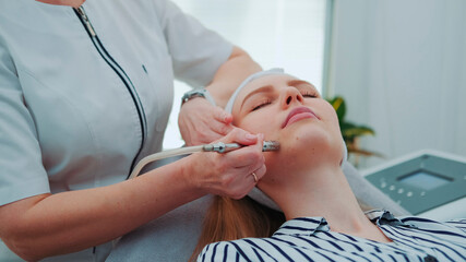 Close up of young woman getting vacuum microdermabrasion. Peeling treatment at cosmetic beauty spa clinic.