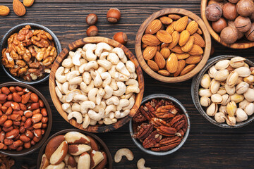 Nuts in assortment, Walnuts, pecans, almonds and other. Healthy food snack mix on wooden table background, top view