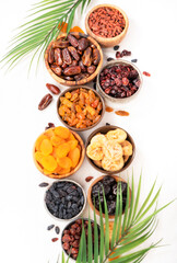 Natural sun dried fruits assortment in bowls on white background. Healthy wholesome snacks. Copy space