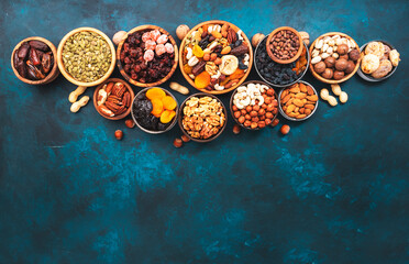 Nuts and dried fruits in assortment. Dry apricots, figs, raisins, walnuts, almonds and other. Blue table background, top view, copy space
