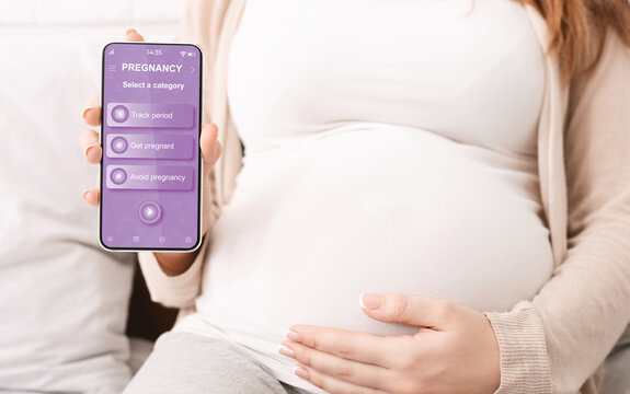 Pregnant woman showing mobile application for pregnancy