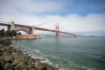 The Golden Gate Bridge in San Francisco, California, from a Fishing Pier with Fog and Clouds