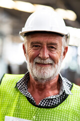 Portrait of senior engineering architect builder wearing protective hardhat working at Metal lathe industrial manufacturing factory. Engineer Operating  lathe Machinery. Elderly people