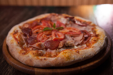 Close up of delicious fresh meat pizza with ham and salami