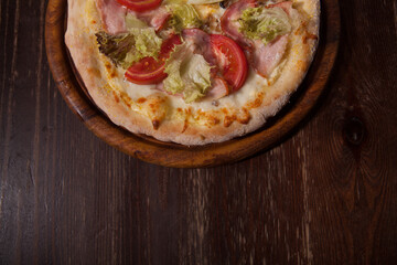 Top view cropped shot of fresh pizza carbonara served on a wooden plate