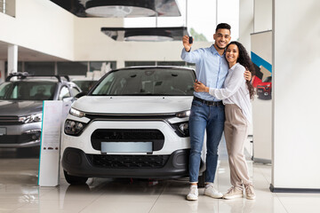 Fototapeta na wymiar Cheerful arab man and woman posing over their new auto