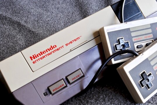 The Nintendo Entertainment System (NES), an 8-bit third-generation home video game console produced by Nintendo. NES Control Deck home video game console with controllers.