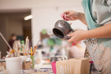 Cropped shot of unrecognizable female potter making kitchenware mug at her art studio