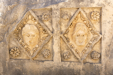 half-erased stone-cut masks on the ruins of a building in the ancient city of Mira, Turkey