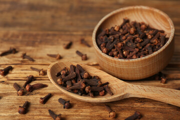 Aromatic dry cloves on wooden table, closeup