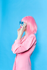glamorous woman in pink dress with blue glasses studio