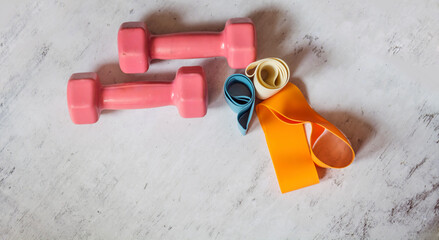 Hand weights and multi-colored elastic rubber bands for fitness with copy space .Top view 