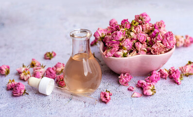 Rose  essential oil in glass bottle and pink rose flowers . Rose water 