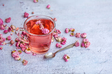 Rose buds tea in a glass cup .
Tea made from tea rose petals