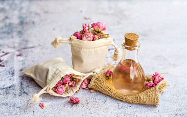 Rose  essential oil in glass bottle and pink rose flowers . Rose water 