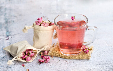 Rose buds tea in a glass cup .
Tea made from tea rose petals