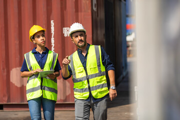 Hispanic Man worker and woman Supervisor dock cargo checking and control loading Containers box at container yard port of import and export goods. Unity and teamwork concept