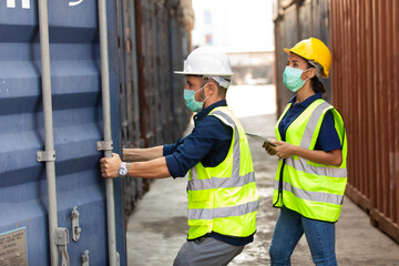 professional team man and woman worker wearing protection face mask during coronavirus and flu outbreak and wearing safety hardhat helmet at container yard or cargo warehouse