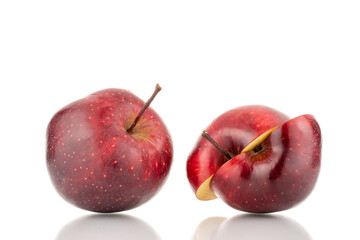 One whole and two halves of a ripe red apple, close-up, isolated on white.