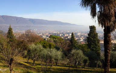 Aerial view of the city of Vittorio Veneto with the mountains in the background. Day with haze.