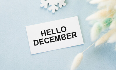 Hello December text on a card on a blue background