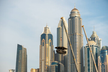 Dinner in the sky restaurant in front of Iconic Dubai Marina buildings. Modern hotels, luxury apartments, business centers and famous tourists attraction.