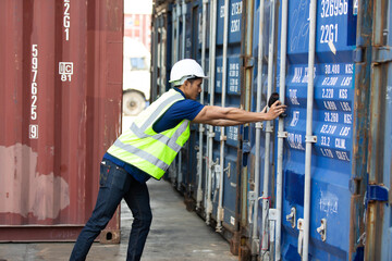 Engineering man worker wearing hardhat safety helmet and vest opening container door in  logistic shipping yard. Marine and carrier insurance concept. Cargo container yard.