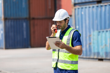 foreman manager working through a radio communication with the workers in the container yard at...