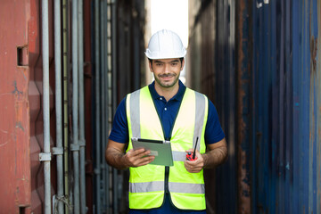 foreman manager working through a radio communication with the workers in the container yard at port of import and export goods.