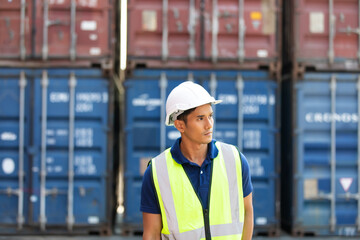 Marine and carrier insurance concept. Cargo container yard. Portrait Asian man engineer worker wearing hardhat safety helmet and vest working in  logistic shipping yard.