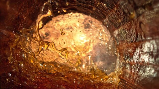 Super Slow Motion Shot of Splashing Whiskey in Old Oak Barrel at 1000fps.