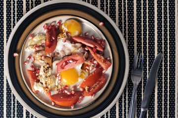 breakfast on a plate - bacon with tomatoes and eggs - top view