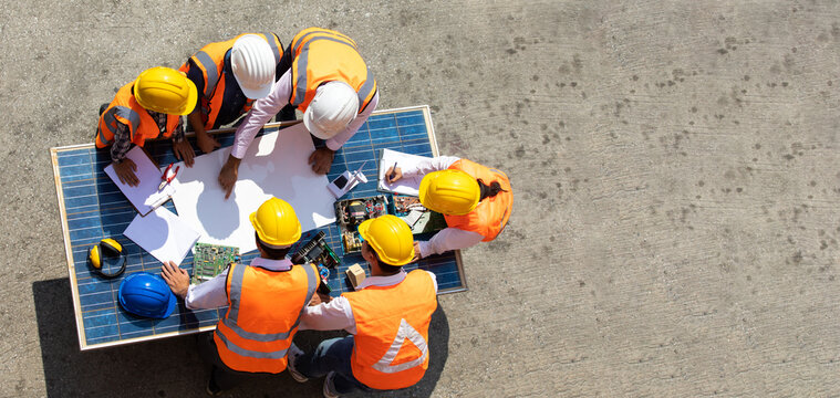 Ethnic diversity worker people, Success teamwork. Group of professional engineering people wearing hardhat safety helmet meeting with solar photovoltaic panels discussion in new project