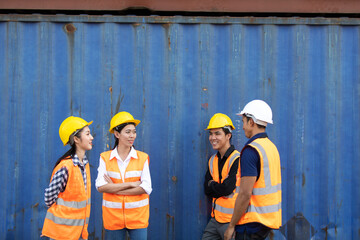 Group of professional dock worker and engineering people wearing hardhat safety helmet and vest working at container yard port of import export. Business teamwork concept
