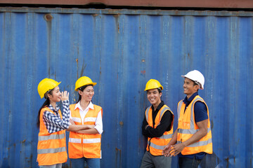 Group of professional dock worker and engineering people wearing hardhat safety helmet and vest working at container yard port of import export. Business teamwork concept