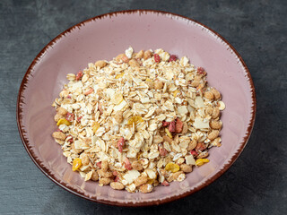 Muesli in a cup on a gray table.