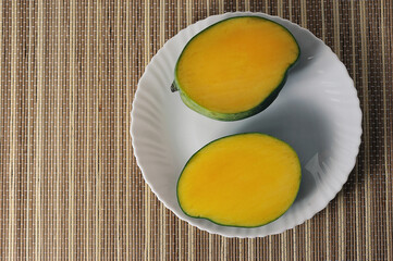 green yellow mango on a reed lining