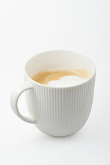 Coffee in a white mug with milk foam in a white mug isolated on a white background