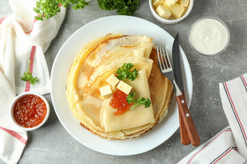 Concept of tasty food with crepes on gray textured background