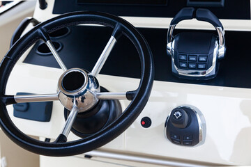 Luxury yacht control panel with steering wheel, gear levers, navigation devices and control buttons.
