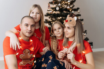 A family in red T-shirts celebrating Christmas in the kitchen
