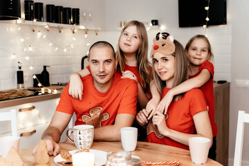 A family in red T-shirts celebrating Christmas in the kitchen